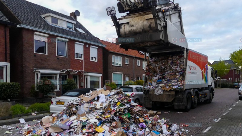 Vuilniswagen dumpt papier op straat in woonwijk Enschde